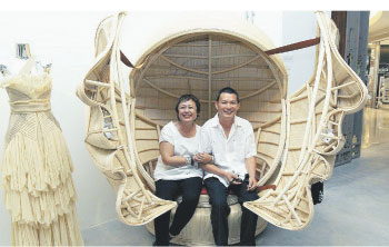 Izan (left) and Chan’s giant rattan sculpture opens up to reveal a love seat inside while the dress by Ong, also takes inspiration from rattan
