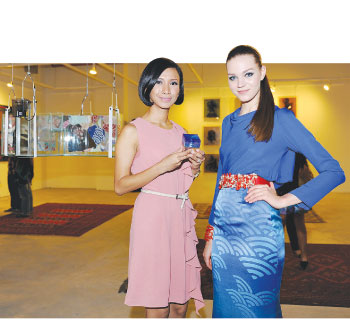 Izrin (left) beside Dhavinder’s suspended aquarium and a model wearing her striking, oceanic print blue gown